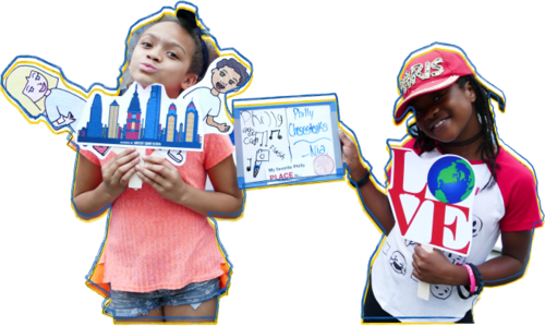 Two young students are posing for a picture holding various posters and signs. The student on the right is wearing a pink shirt and jean shorts, she is holding a cut out of a city skyline and a cartoon boy and girl. The student on the right is wearing a red baseball cap. She is holding a white board that has writing and drawings on it and a cutout of the LOVE statue.